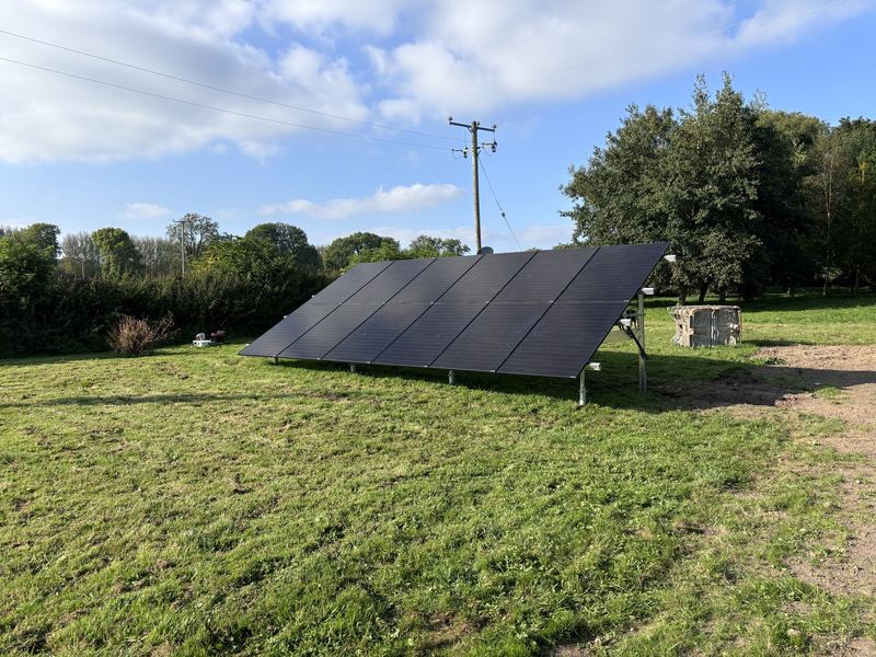 Ground mounted solar panel array installed in a field beside a house in Ireland